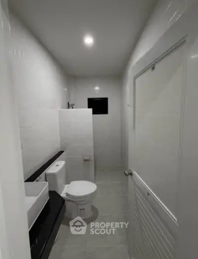 Modern minimalist bathroom with sleek fixtures and white tiles, perfect for a contemporary home.