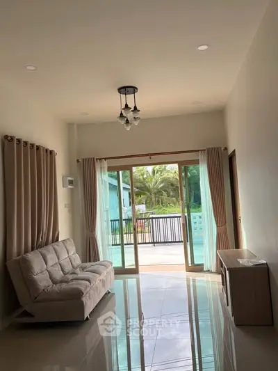 Spacious living room with modern decor and large sliding glass doors leading to a balcony with a scenic view.