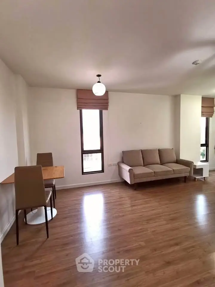 Spacious living room with modern furniture and wooden flooring, perfect for relaxation and entertaining.