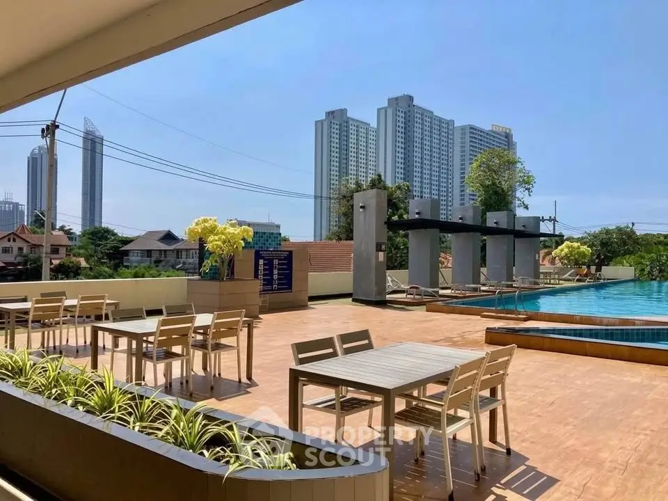 Luxurious rooftop pool area with city skyline views and modern outdoor seating.