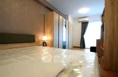 Spacious bedroom with large bed, modern wood-panel wardrobe, and cozy ambiance lighting, perfect for relaxation and comfort.