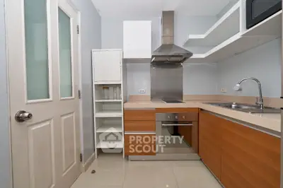 Modern kitchen with sleek cabinetry and stainless steel appliances in compact layout.