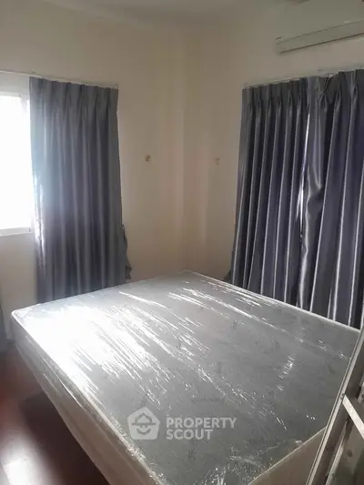 Cozy bedroom with natural light and air conditioning, featuring a new mattress and elegant curtains.