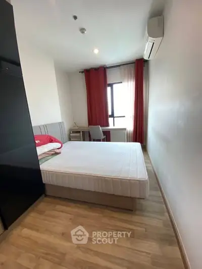 Cozy bedroom with natural light, featuring a comfortable bed and modern decor.