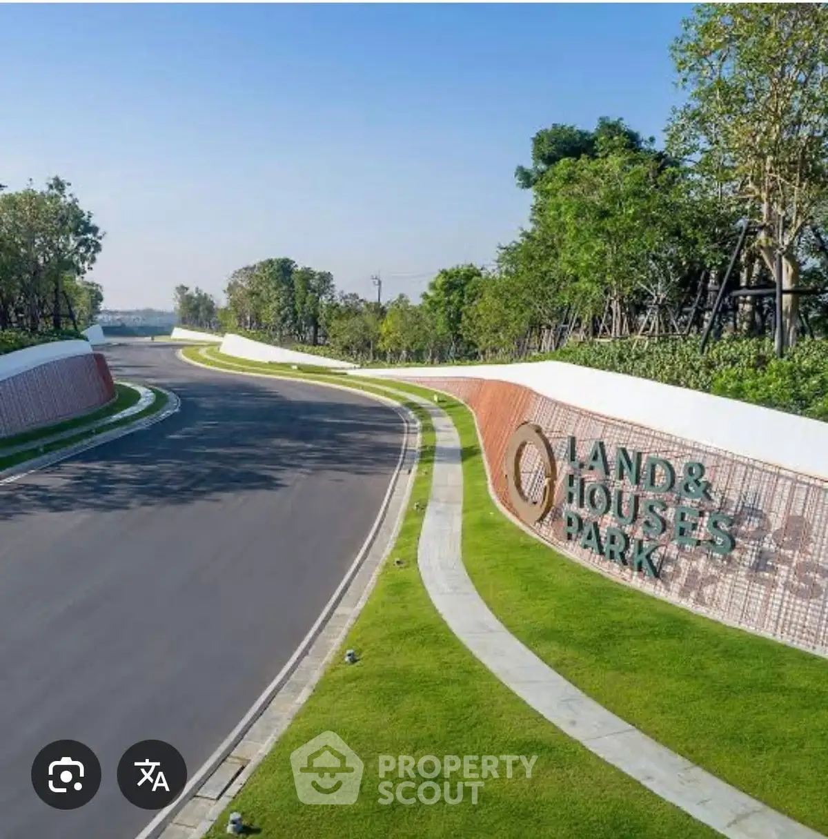 Scenic entrance of Land & Houses Park with lush greenery and modern design.