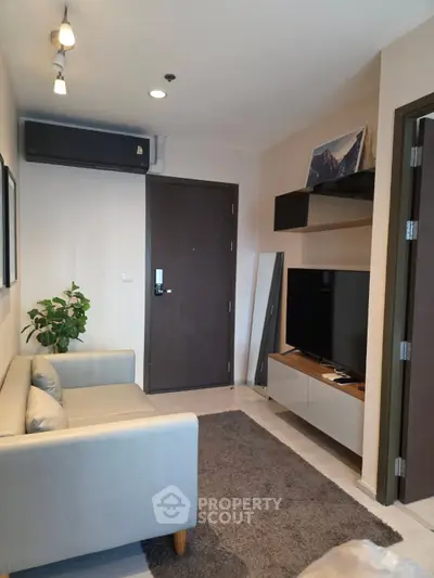 Modern living room with cozy sofa, TV, and stylish decor in a contemporary apartment.