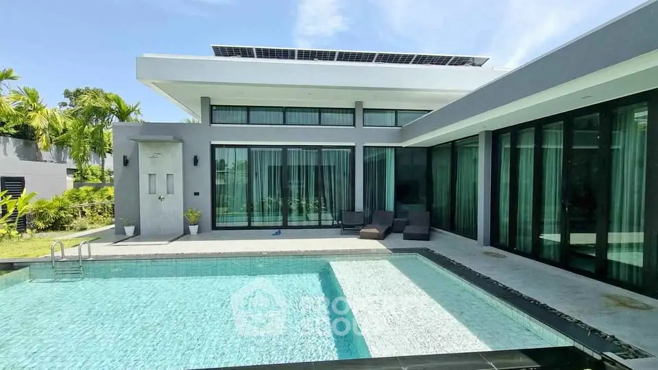 Luxurious modern villa with private pool and sleek glass facade, perfect for tropical living.