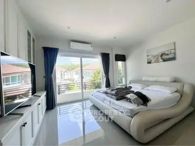 Spacious bedroom with modern decor and large window offering natural light and scenic view.
