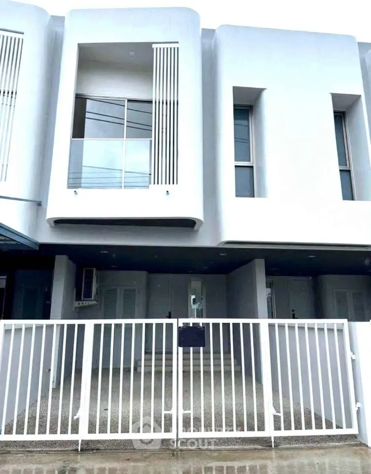 Modern townhouse exterior with sleek design and gated entrance, perfect for urban living.