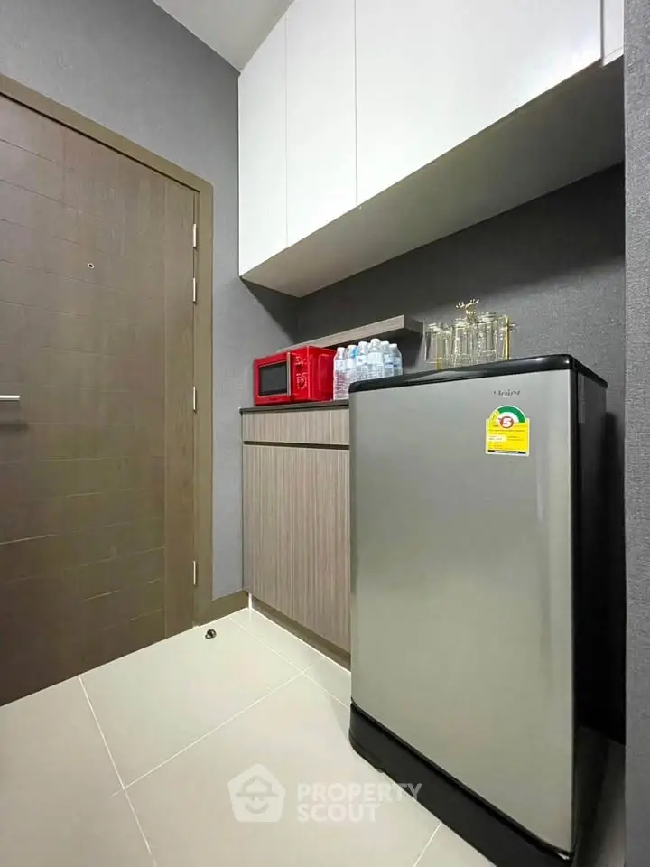 Modern kitchen with compact fridge and microwave in sleek apartment