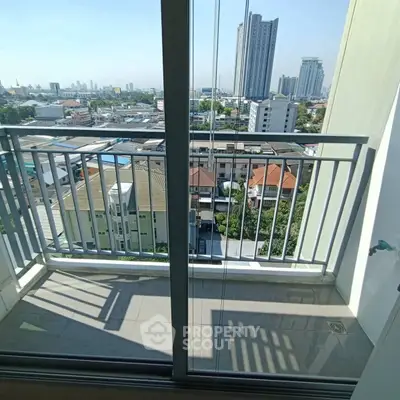 Modern apartment balcony with stunning city view and sleek glass doors.