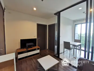 Modern living room with sleek furniture and natural light streaming in from the balcony, perfect for urban living.