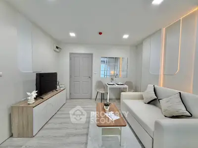 Modern living room with sleek furniture and stylish decor, featuring a cozy sofa and entertainment unit.