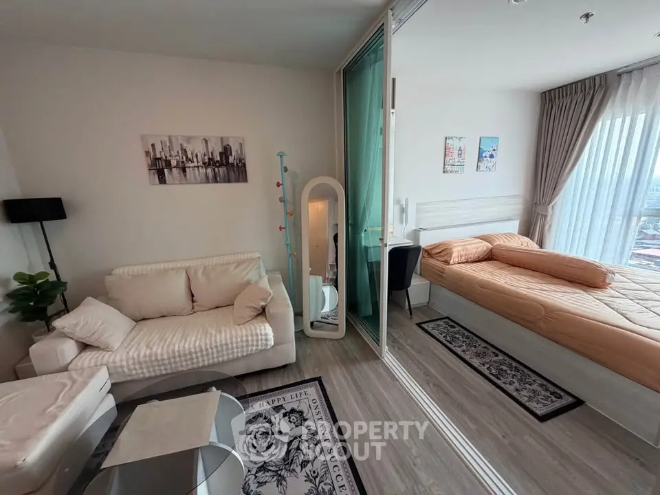 Modern studio apartment with cozy living area and bedroom, featuring stylish decor and natural light.