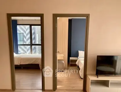 Modern apartment interior with two bedrooms and a cozy living area featuring a TV stand.