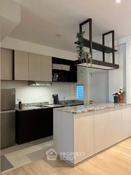 Modern kitchen with granite countertops and sleek cabinetry in a stylish apartment.