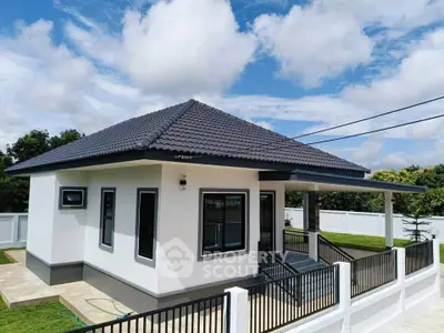 Charming modern bungalow with sleek roof and spacious yard under blue skies.