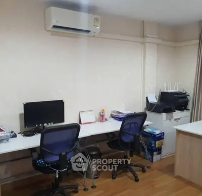 Modern home office with dual desks, chairs, and air conditioning