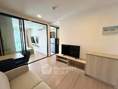 Modern living room with sleek furniture and glass partition in a stylish apartment.