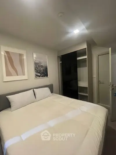 Cozy bedroom with modern decor and ample storage space in a stylish apartment.