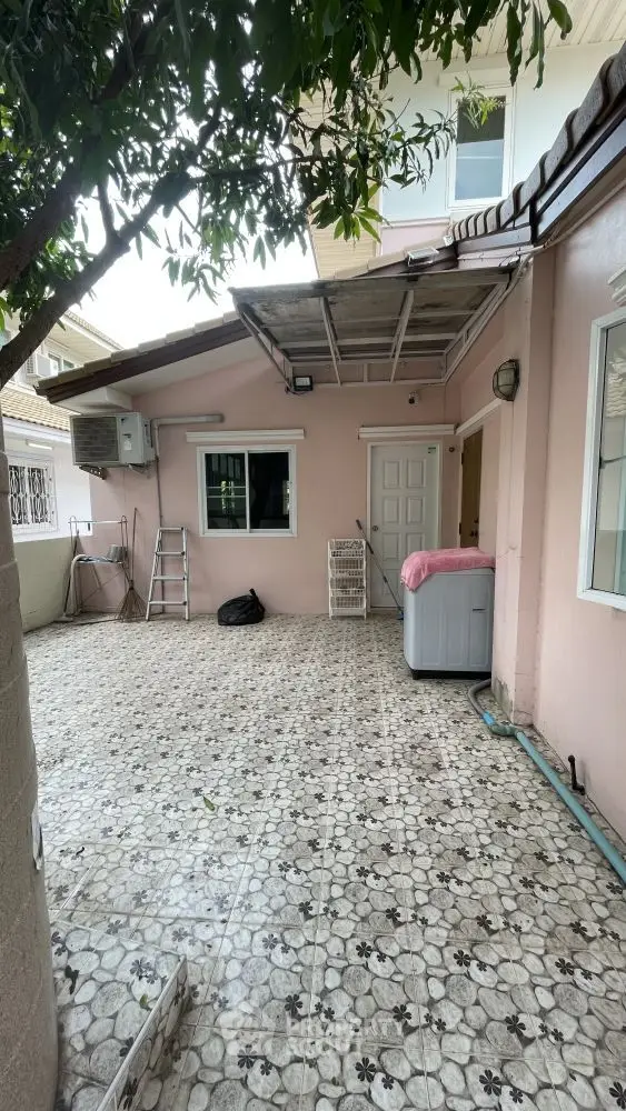 Charming exterior patio with tiled flooring and laundry area in a cozy residential home.