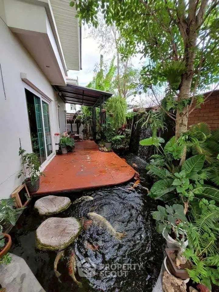 Charming garden with koi pond and lush greenery in a modern home exterior