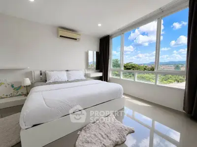 Spacious bedroom with large windows offering stunning views and abundant natural light.