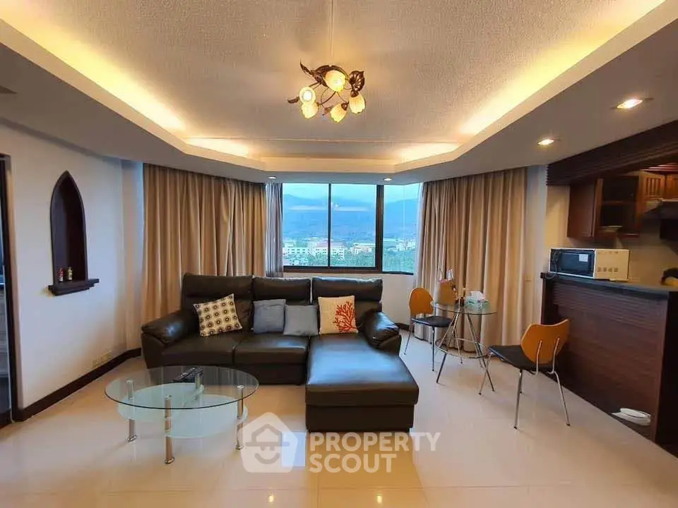 Spacious living room with modern decor and stunning mountain view, featuring a cozy sectional sofa and elegant lighting.