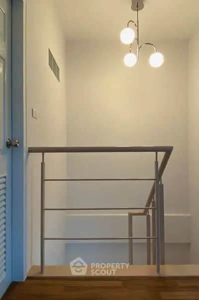 Modern staircase with sleek railing and stylish lighting in a contemporary home.
