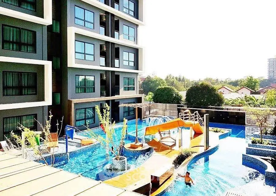 Modern apartment building with vibrant pool and slide, perfect for family living.