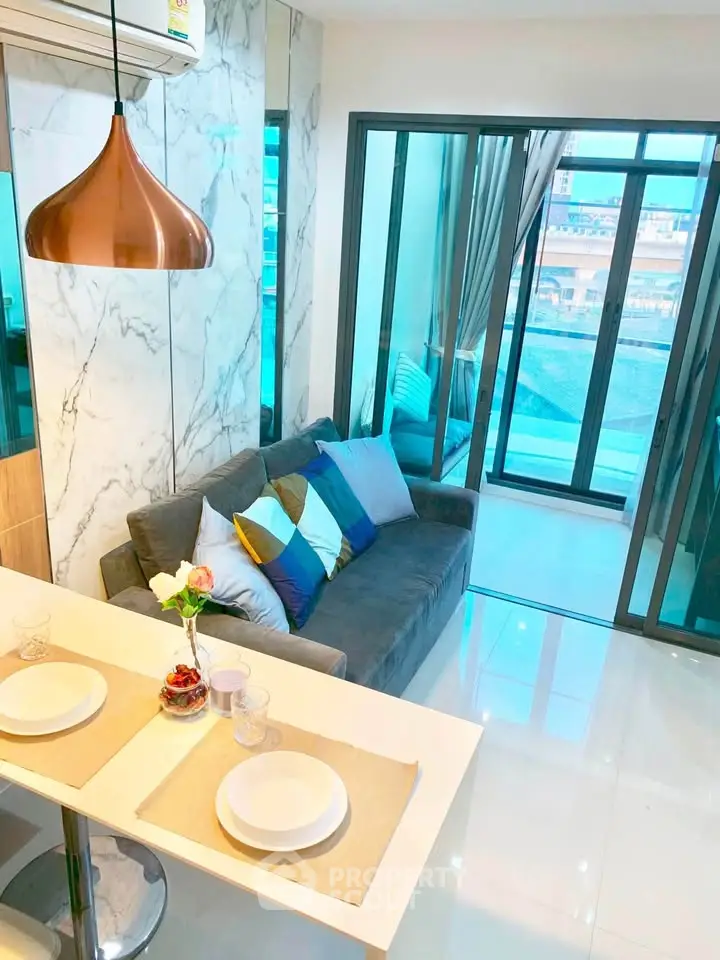 Modern living room with marble accents and large windows offering a stunning city view.