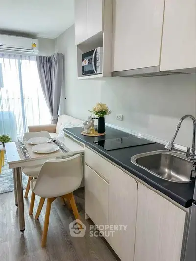 Modern compact kitchen with dining area and natural light