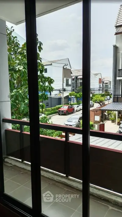 Charming balcony view overlooking a suburban neighborhood with modern houses and lush greenery.