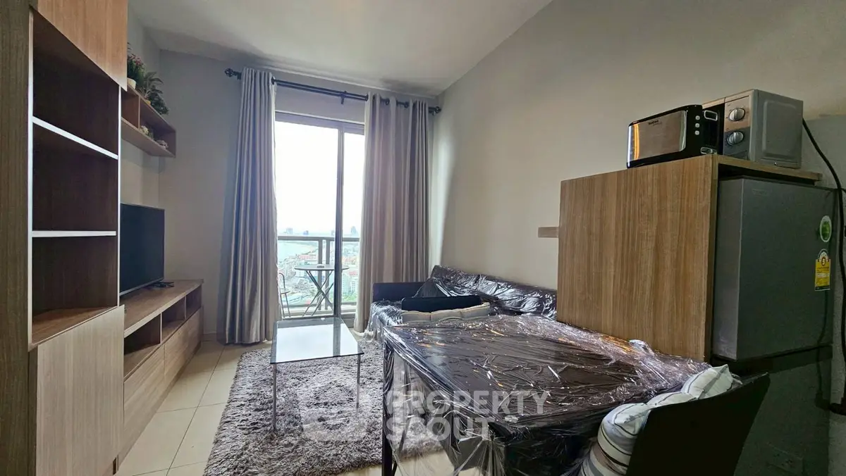 Cozy living room with balcony, modern furniture, and natural light