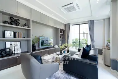 Luxurious modern living room with elegant decor and large windows offering natural light.
