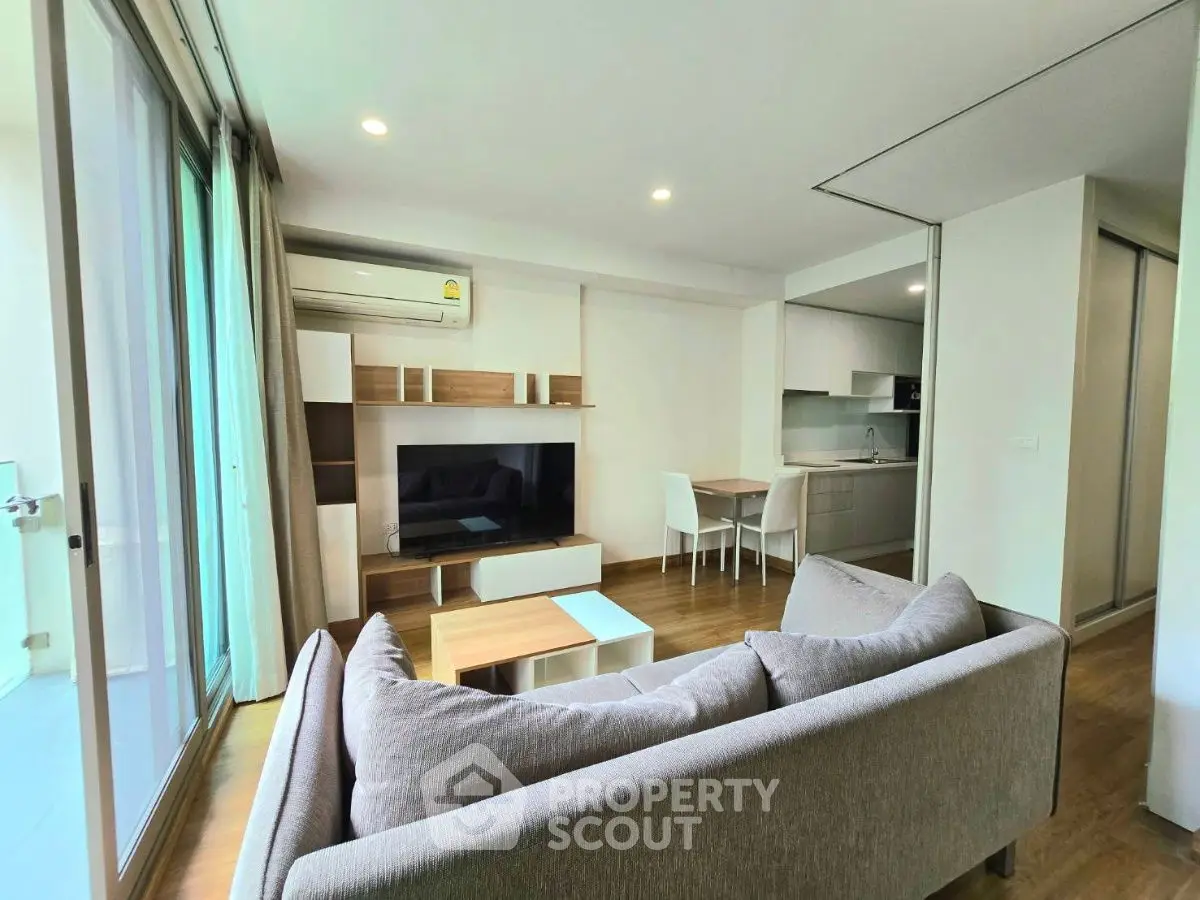 Modern living room with cozy sofa and open kitchen in stylish apartment