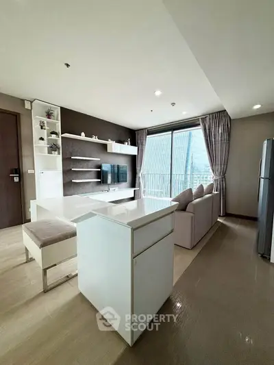 Modern living room with sleek furniture and city view through large windows.