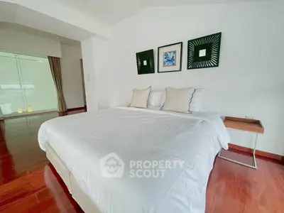 Spacious bedroom with elegant decor and hardwood floors in modern real estate property.