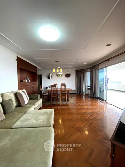 Spacious living room with elegant parquet flooring and large balcony access.