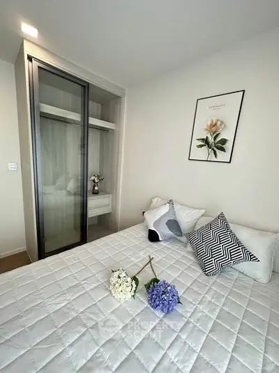 Modern bedroom with stylish decor and built-in wardrobe, featuring elegant floral accents.