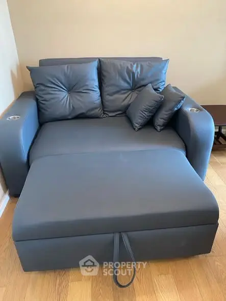 Modern blue sofa bed with cushions in a cozy living room setting.