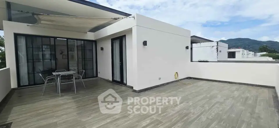 Modern rooftop terrace with mountain views and stylish outdoor seating.