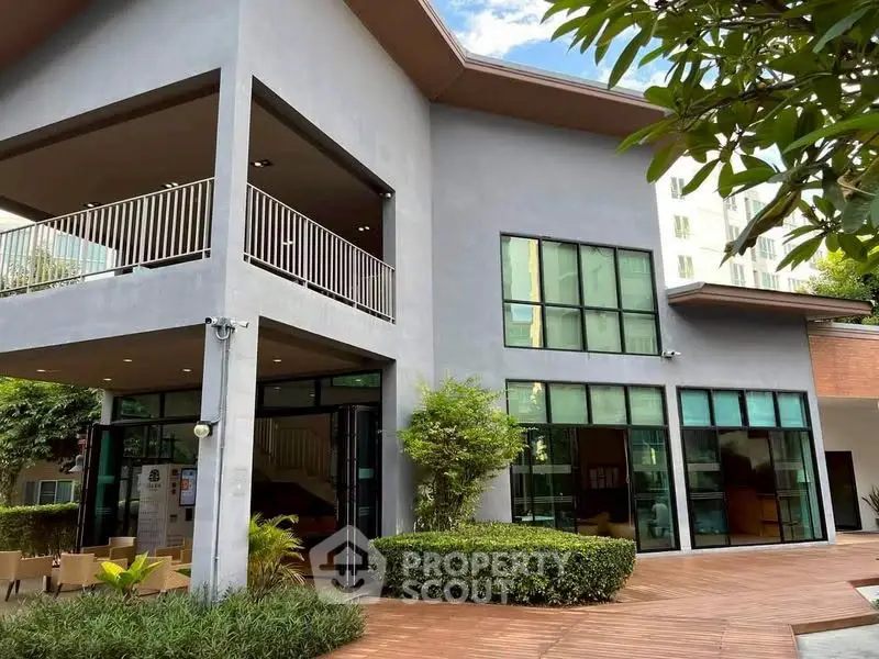 Modern building exterior with large windows and lush greenery, perfect for commercial or residential use.