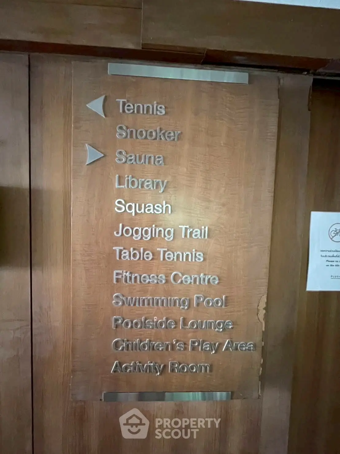 Luxury apartment amenities list including tennis, pool, gym, and more on elegant wooden panel.