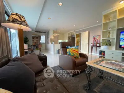 Spacious living room with modern decor and open kitchen layout in a luxury apartment.