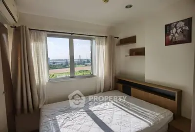 Cozy bedroom with large window offering scenic views and natural light.