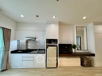 Modern kitchen with sleek cabinetry and stylish backsplash in a bright apartment.