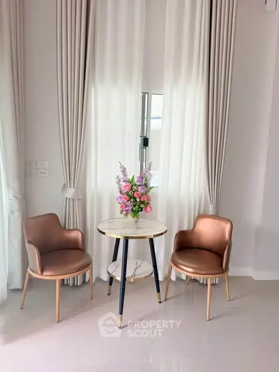 Elegant interior with stylish chairs and floral centerpiece in a bright, airy room.