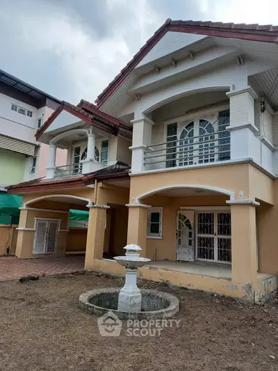Charming two-story house with unique architectural design and spacious front yard.