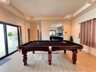 Spacious living room with elegant pool table and modern decor